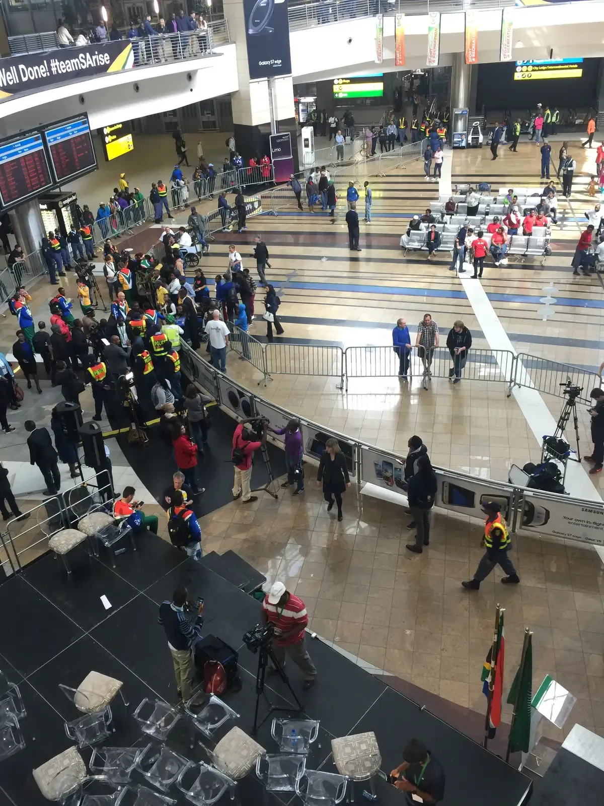 The international arrivals concourse at OR Tambo airport seen from above, crowds moving between gates